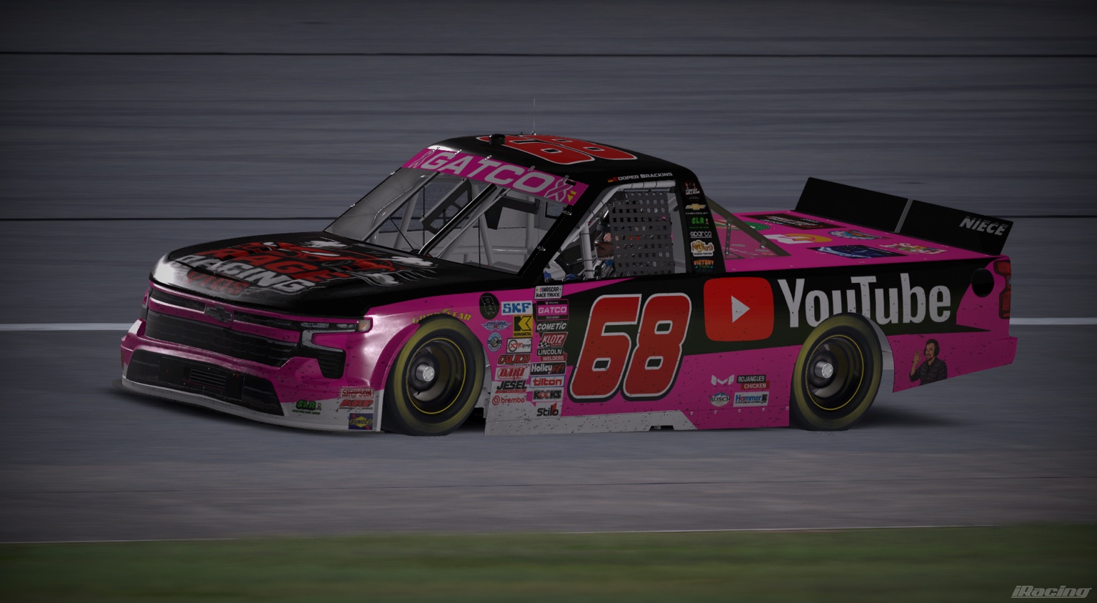 Black and pink number 68 YouTube Chevrolet truck on track